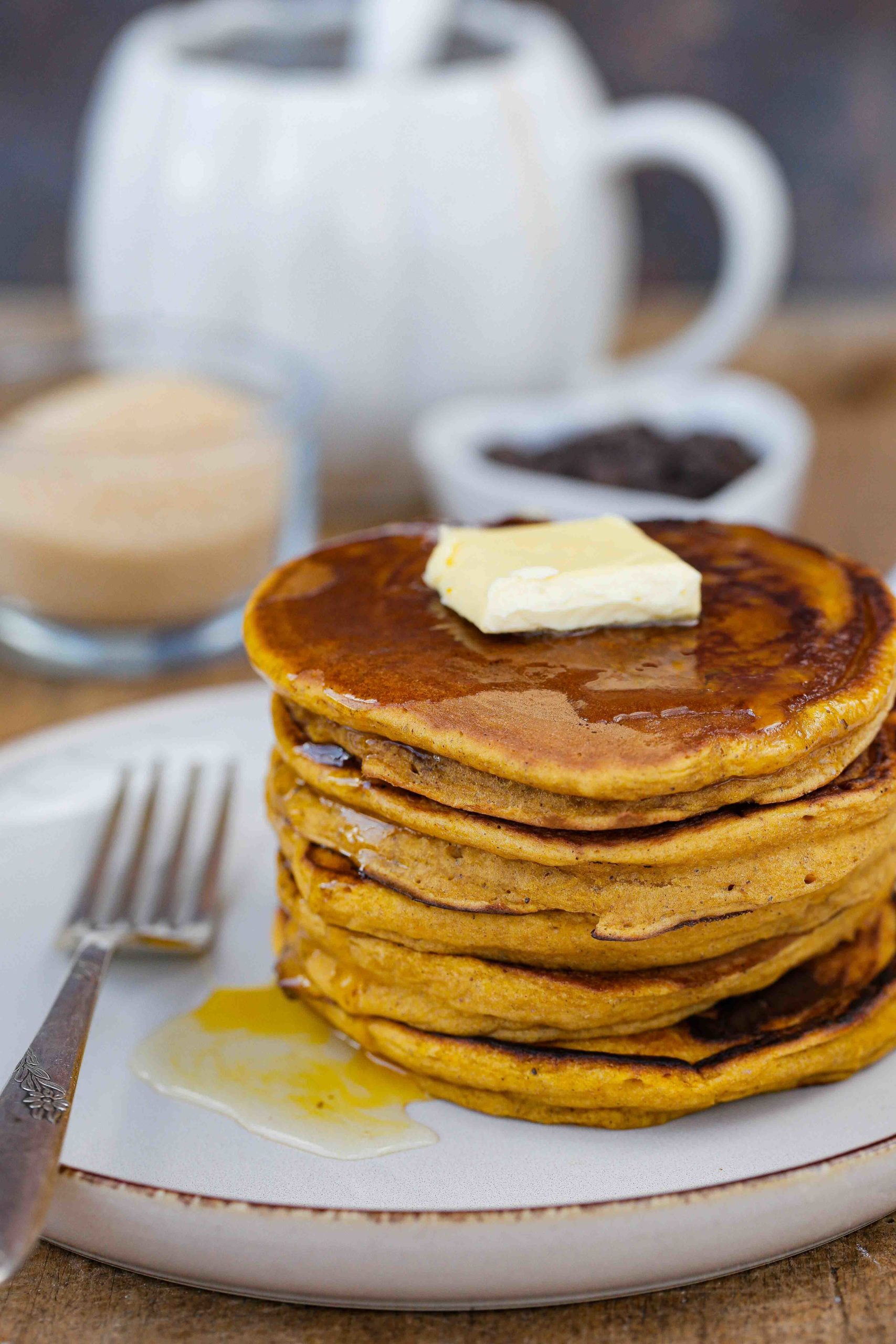 These easy to make, super fluffy vegan pumpkin pancakes with warming spices are the perfect cosy autumn breakfast! Recipe on thecookandhim.com | #pumpkinpancakes #veganpancakes #fluffyveganpancakes #veganbreakfast #eggfreepancakes #autumnrecipes