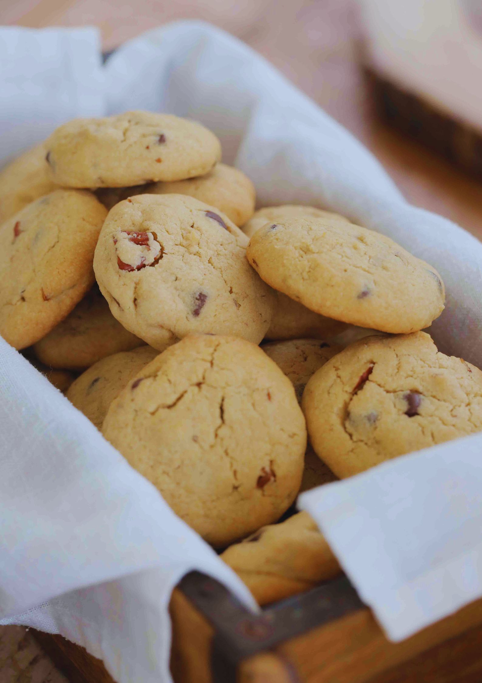 These chewy vegan choc chip cookies with tahini and pecans are super easy to make with simple ingredients and take less than 15 minutes to bake! Recipe on thecookandhim | #vegancookies #veganchocchipcookies #brownsugarcookies #chewychocchipcookies #egglesscookies