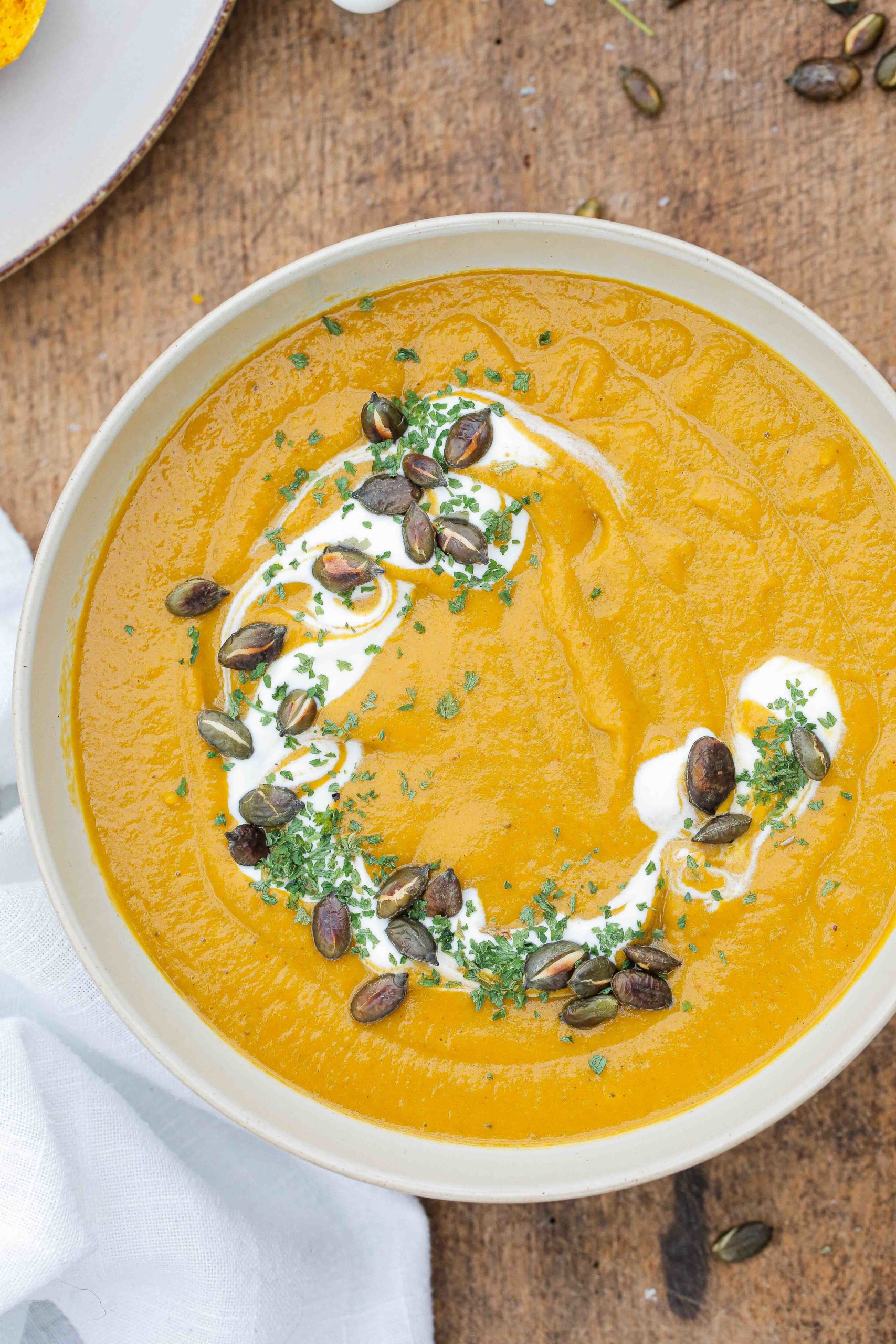 Easy to make but tastes amazing, this pumpkin soup with herbs, garlic and extra veggies is the perfect healthy bowl to warm you up during the chilly months! Recipe on thecookandhim.com #pumpkinsoup #pumpkinrecipes #autumnrecipes #winterwarmerrecipes #prepaheadmeals #fallrecipes