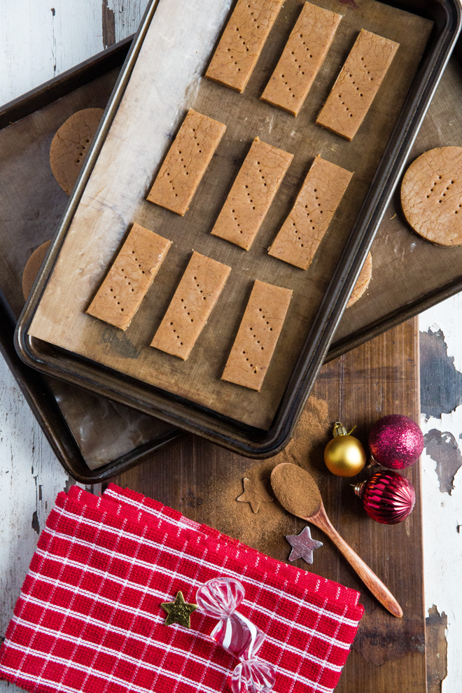Baked with almond butter and warming festive spices these easy Christmas cookies are half dipped in chocolate for an extra special treat! Recipe on thecookandhim.com | #christmascookies #spicedcookies #veganchristmas #veganshortbread