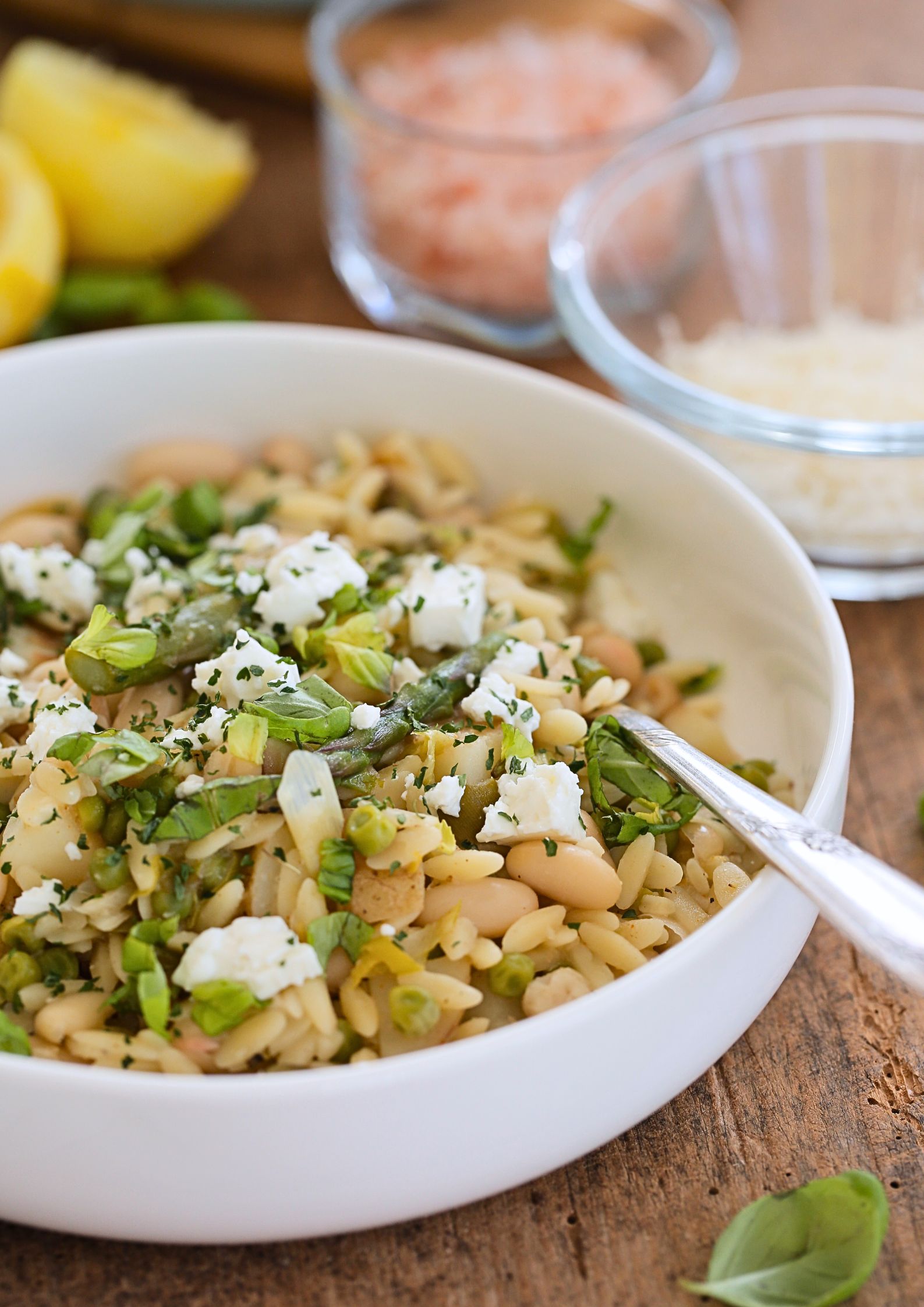 Spring Veggies Orzo Pasta - a lovely light, but jam packed with vegan protein concoction with asparagus, peas, spring onions and fresh basil. Lightened up with zingy lemon. An easy meal whether cooking for one or a houseful! #pastafoodrecipes #pastarecipe #veganrecipe #vegandinner #orzo