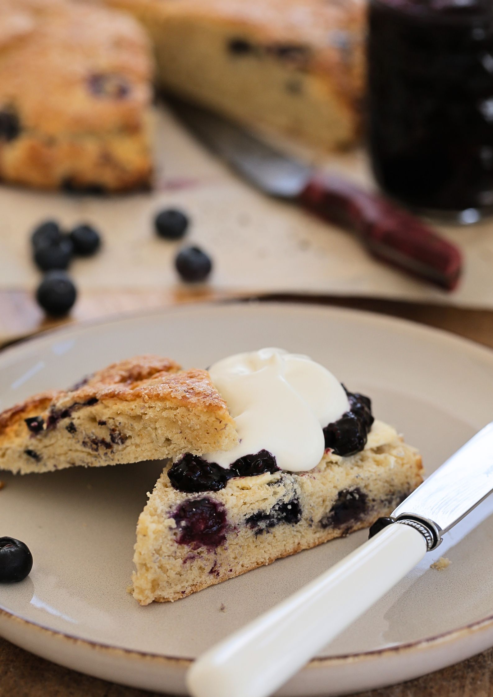 The easiest blueberry scones, made in one bowl with a few simple ingredients. They have a wonderful sugary, crunchy top and are served with an easy homemade blueberry jam and whipped vegan cream for the perfect afternoon tea treat! #veganscones #blueberryscones #eggfree #blueberryjam